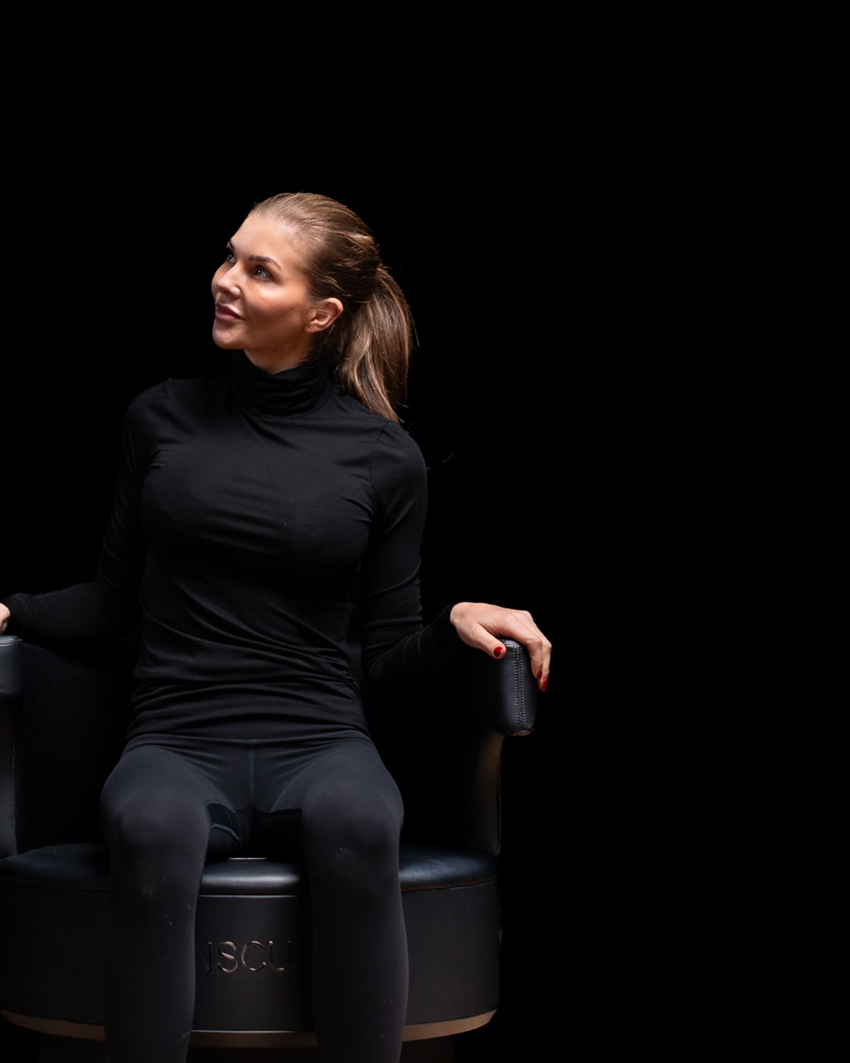 Kvinna som sitter fullt påklädd i Insculpt Chair under en bäckenbottenbehandling